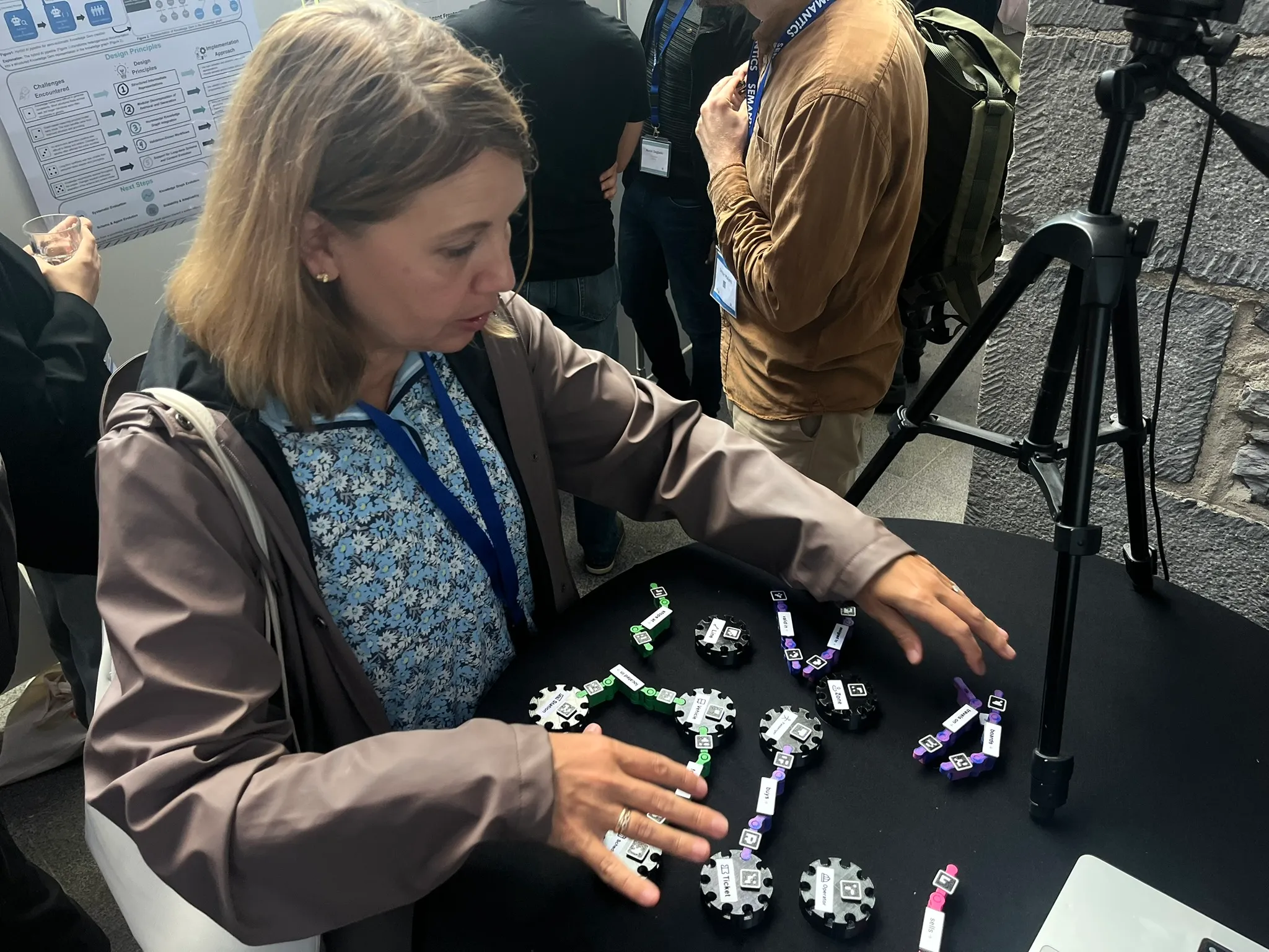 An attendee arranging nodes and links on the black demo table.